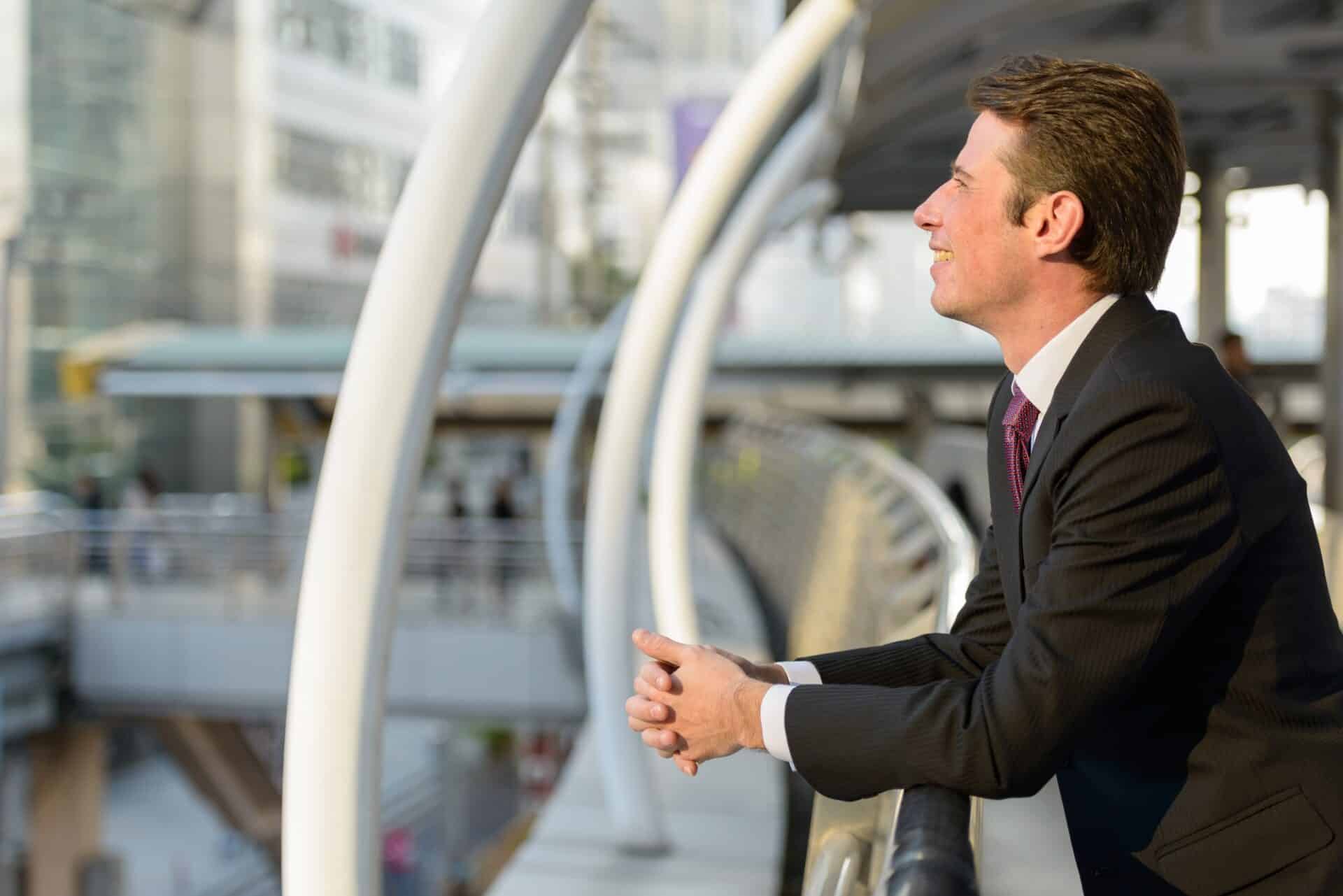 Profile view of happy businessman smiling and thinking in footbr