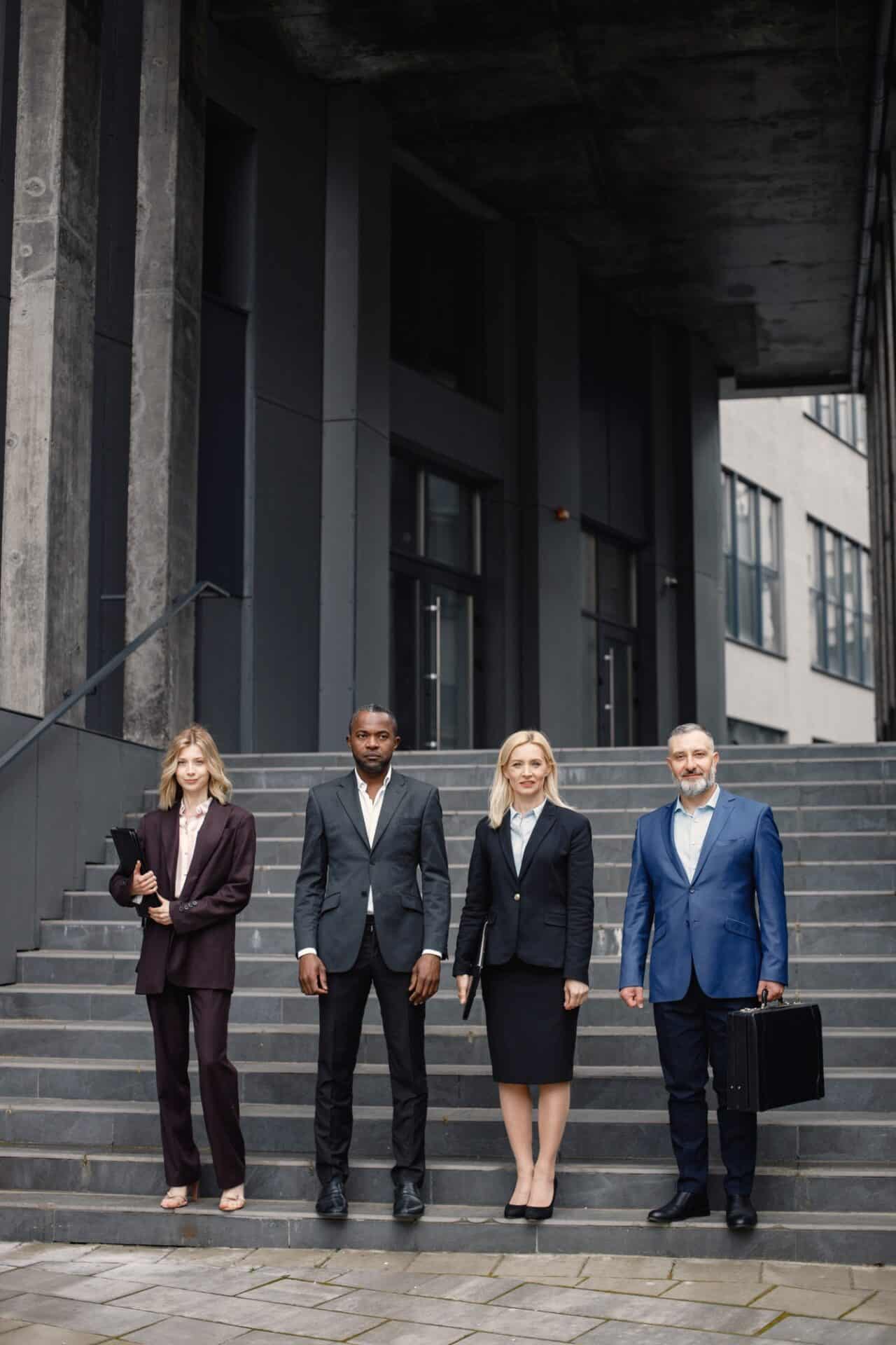 Business people standing in front of modern office and posing for a photo