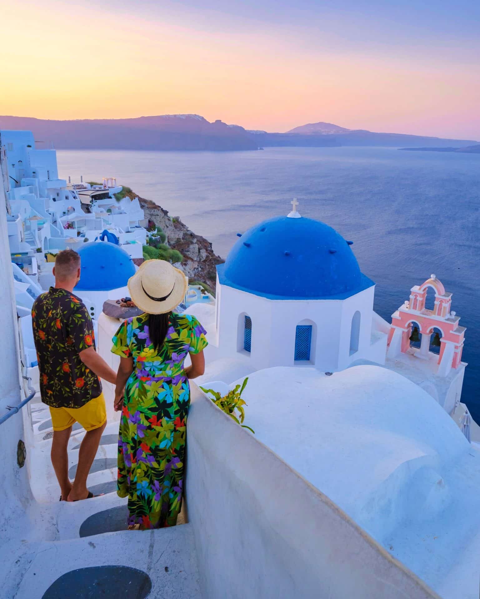 Couple walking at the Greek village of Oia Santorini Greece, men and women on vacation in Greece