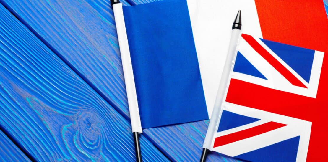 Flags of France and Great Britain on blue wooden background