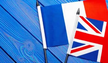 Flags of France and Great Britain on blue wooden background
