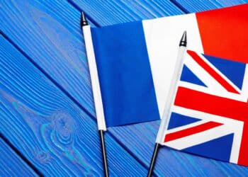 Flags of France and Great Britain on blue wooden background