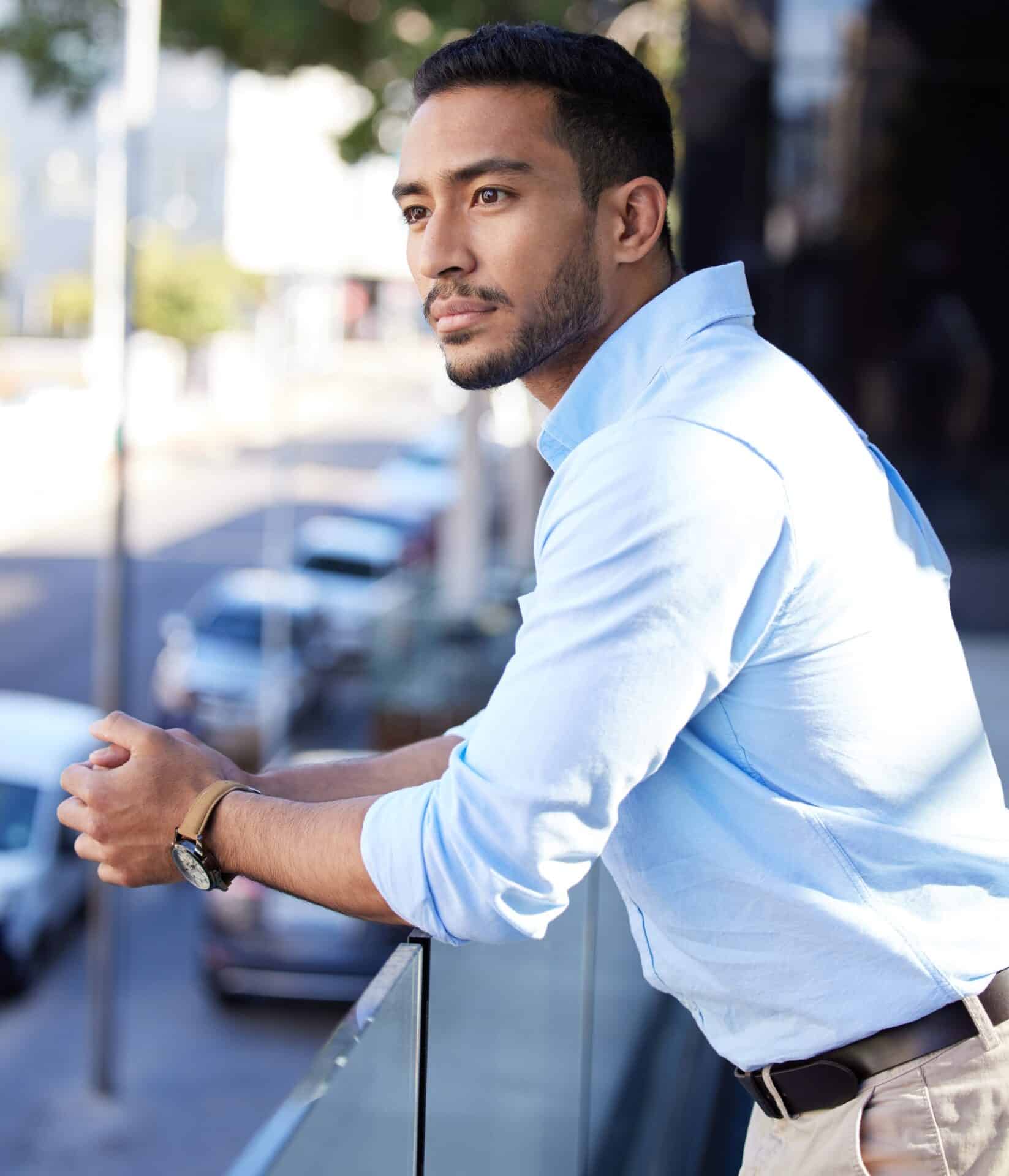 Shot of a young businessman looking thoughtful while standing on the balcony outside an office