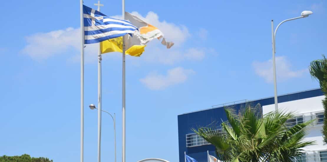 Waving flag of Greece and Cyprus against the blue sky