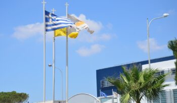 Waving flag of Greece and Cyprus against the blue sky