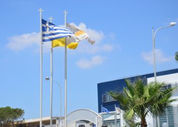 Waving flag of Greece and Cyprus against the blue sky
