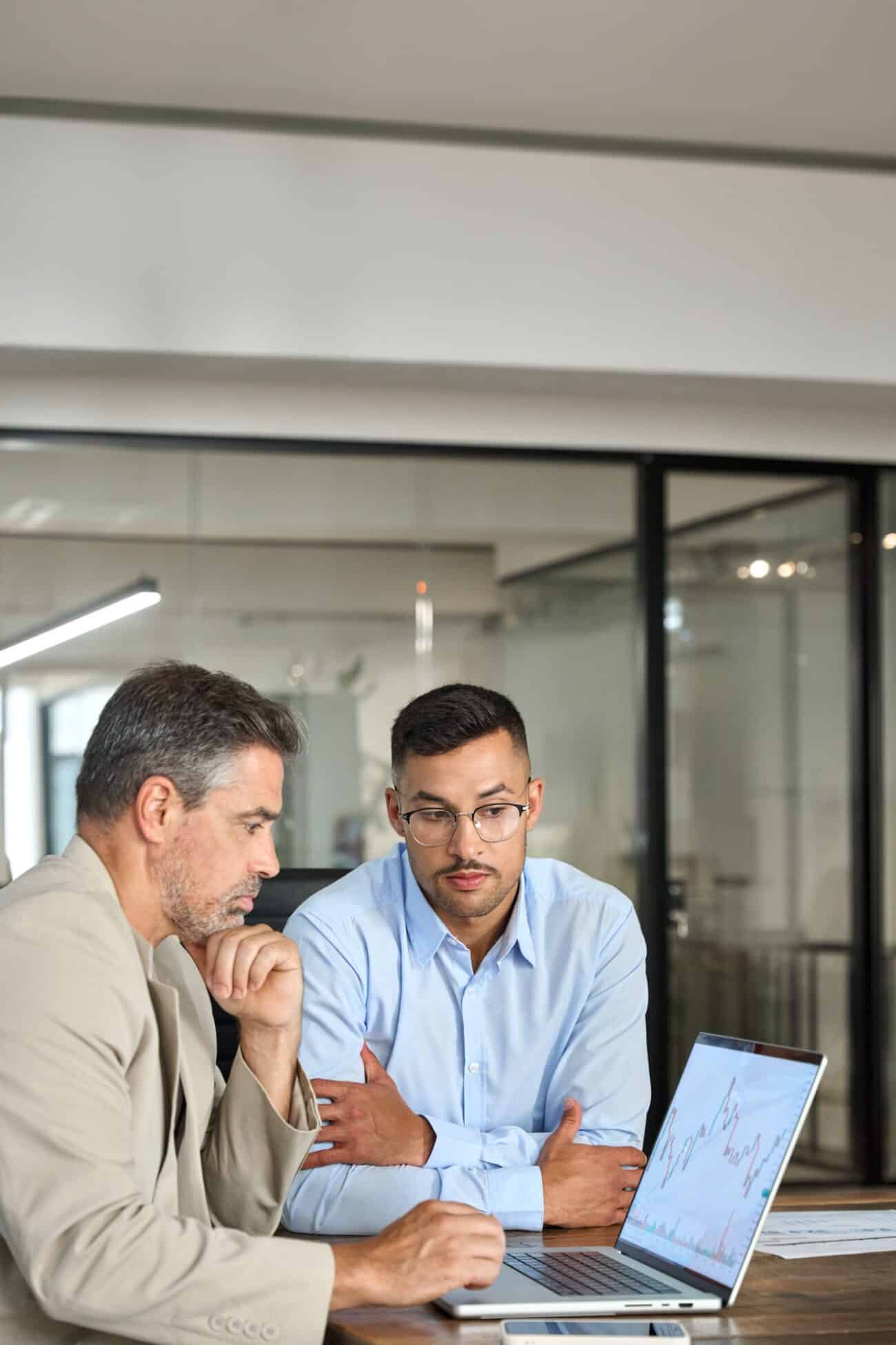 Two busy investors invest in finance trade stock market using laptop. Vertical.